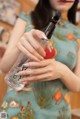 A woman in a blue dress holding a spray bottle.