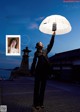 A woman holding an umbrella in front of a building.