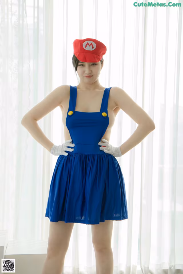 A woman in a blue dress and a red hat.