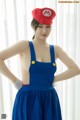 A woman in a blue dress and a red hat.