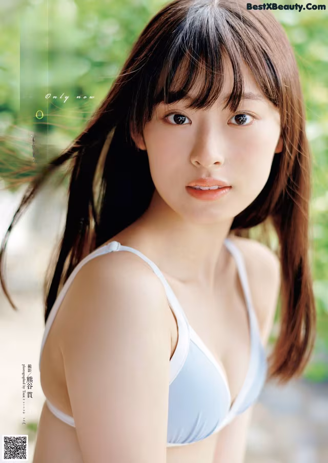 A woman in a blue bikini posing for a magazine cover.