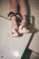 A close up of a person's feet on a tiled floor.