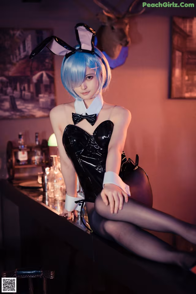 A woman in a bunny costume sitting at a bar.