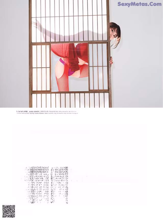 A woman in a red lingerie leaning against a window.