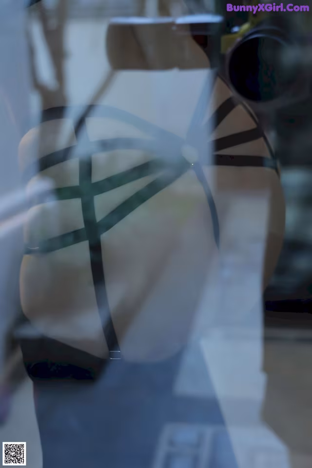 A mannequin in the window of a clothing store.
