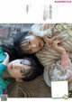 A couple of young women laying on top of a rug.