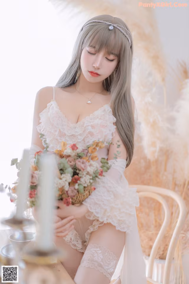 A woman sitting on a chair holding a bouquet of flowers.