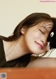 A woman laying on top of a bed with a stuffed animal.