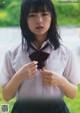 A young woman in a school uniform is posing for a picture.