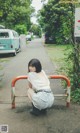 A woman sitting on a bench in the middle of a street.