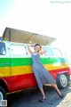 A woman standing in front of a colorful van.