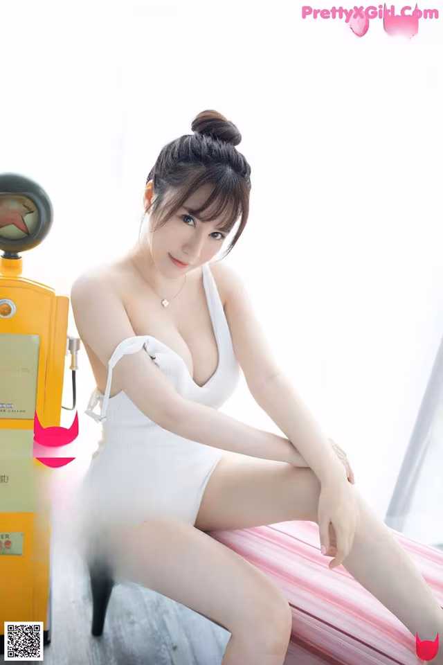 A woman sitting on top of a bed next to a gas pump.