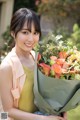 A woman holding a bouquet of flowers in her hands.