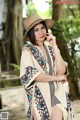 A woman in a straw hat is posing for a picture.