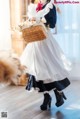 A woman in a white dress holding a basket of flowers.