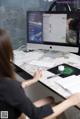 A woman sitting at a desk in front of a computer.