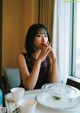 A woman sitting at a table with a cup of coffee.