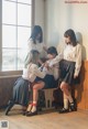 A group of young women sitting on top of a wooden bench.