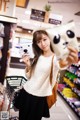 A woman holding up a stuffed animal in a store.