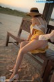 A woman sitting on a bench on the beach.