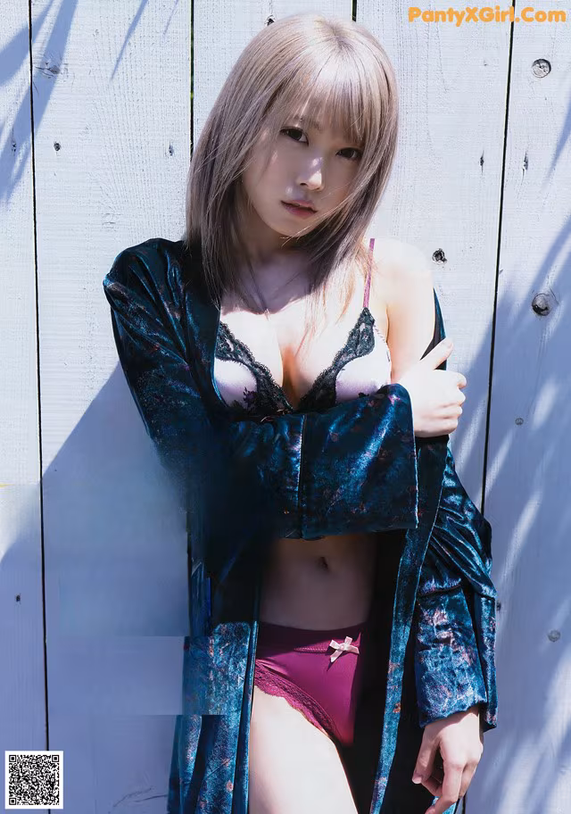 A woman in lingerie posing in front of a wooden wall.